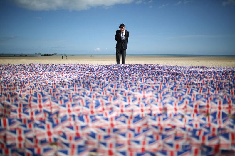 WW2 veteran Fred Holborn, from the Fleet Air Arm, looks at British Legion Union flags carrying thank you messages planted in the sand on Gold beach on June 5, 2014 near Asnelles, France. 20,000 paper flags are being planted. Peter Macdiarmid / Getty