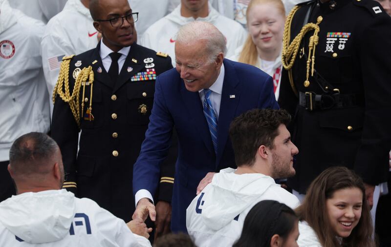 US President Joe Biden greets an Olympian. Reuters