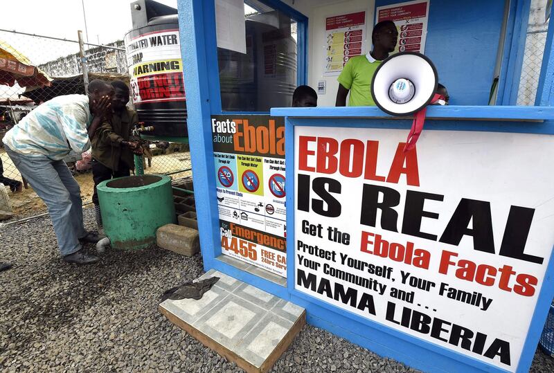 Liberians wash their hands next to an Ebola information and sanitation station, raising awareness about the virus in Monrovia, on September 30, 2014. AFP