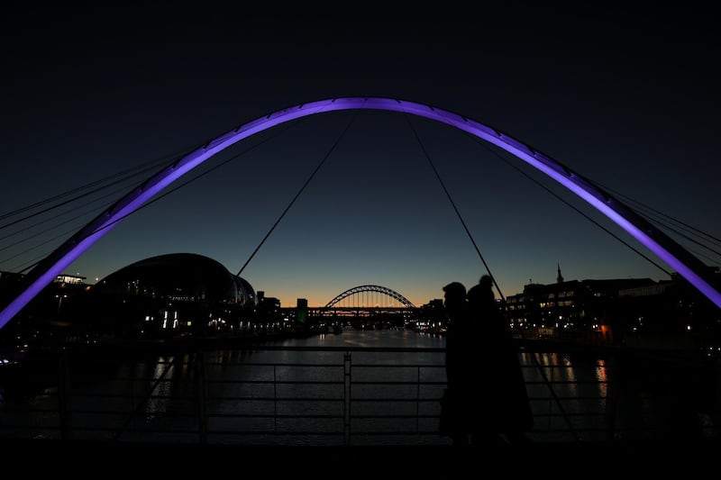 People walk during the sunset ahead of the start of tier 4 restrictions in Newcastle. Reuters