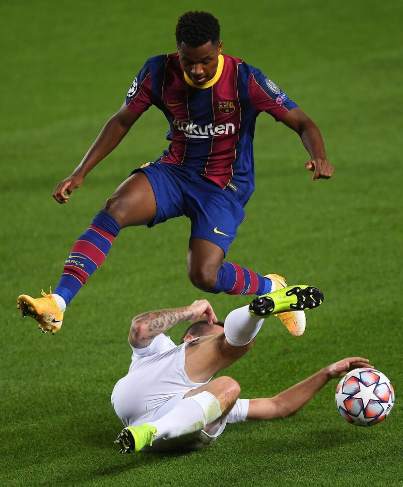 BARCELONA, SPAIN - OCTOBER 20: Ansu Fati of FC Barcelona is challenged by Endre Botka of Ferencvaros Budapest during the UEFA Champions League Group G stage match between FC Barcelona and Ferencvaros Budapest at Camp Nou on October 20, 2020 in Barcelona, Spain. Sporting stadiums around Europe remain under strict restrictions due to the Coronavirus Pandemic as Government social distancing laws prohibit fans inside venues resulting in games being played behind closed doors. (Photo by Alex Caparros/Getty Images)