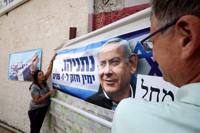 Israelis hang a poster of Likud party candidate Benjamin Netanyahu in the southern city of Beersheva in the run up to Israel's election on November 1. AFP