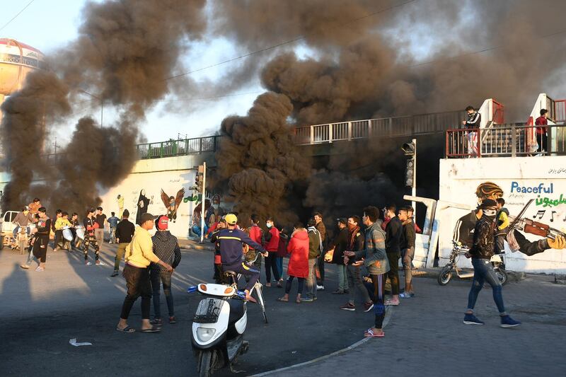 Iraqi Anti-government demonstrators block a road with debris and burning tires in the southern Iraqi city of Nasiriyah.   AFP