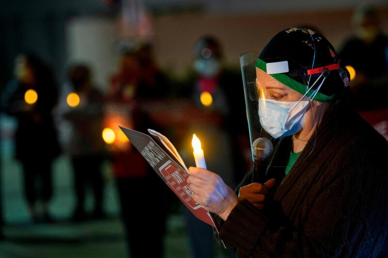 A nurse reads names of healthcare workers who died from Covid-19 during a vigil organized by California Nurses United outside of UCLA Medical Center in Los Angeles, California. AFP