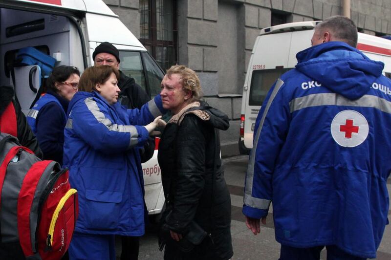 Medics help an injured woman outside the Technological Institute metro station in St Petersburg. Alexander Tarasenkov / AFP
