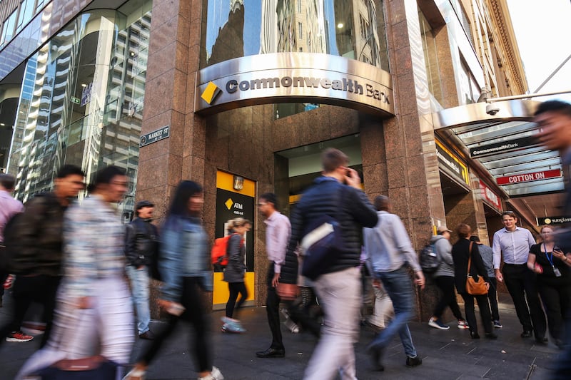 Pedestrians walk past a Commonwealth Bank of Australia branch in Sydney, Australia, on Monday, Aug. 7, 2017. Commonwealth Bank has blamed a software coding error for more than 50,000 alleged breaches of money-laundering and terrorist-financing laws. Photographer: Brendon Thorne/Bloomberg