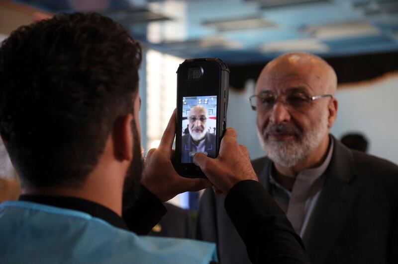 Former chief of National Directorate of Security, Mohammed Masoom Stanekzai, right, poses for a picture, taken by an election official, before casting his vote during the presidential elections in Kabul, Afghanistan. AP Photo