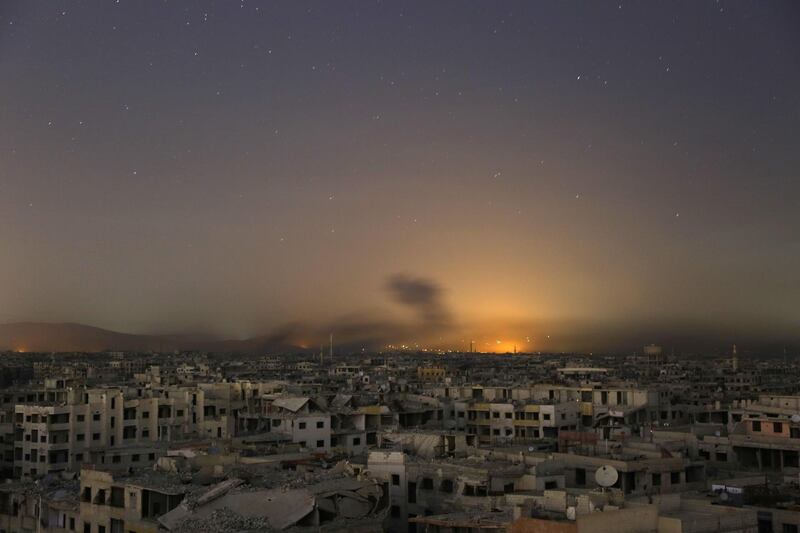 TOPSHOT - Lights and smoke are seen during Syrian government bombardment on the rebel-controlled town of Arbin, in the besieged Eastern Ghouta region on the outskirts of the capital Damascus, on late March 11, 2018.
New air strikes and barrel bombs pounded Syria's Eastern Ghouta as government forces pressed a three-week advance that splintered the rebel enclave and trapped dozens under collapsed buildings. / AFP PHOTO / Ammar SULEIMAN