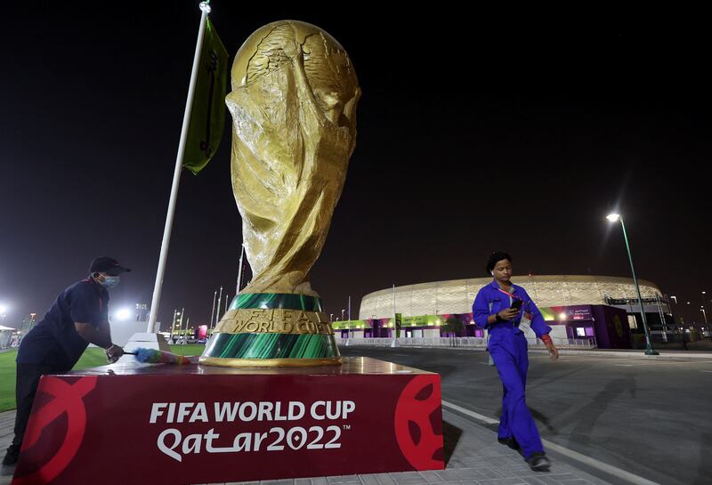 A worker cleans a sculpture of the World Cup trophy in front of Al Thumama Stadium ahead of the World Cup soccer tournament in Doha, Qatar. Reuters