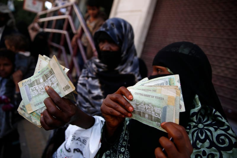 FILE - In this Nov. 14, 2015 file photo, women display paper currency after they received it from the U.N. children's agency in Sanaa, Yemen. UNICEF suspended cash transfers to 9 million of Yemen's most impoverished citizens. The agency said the decision, which entered into effect Wednesday, Oct. 3, 2018, came after it was unable to set up a call center to get feedback from beneficiaries, without providing further details. (AP Photo/Hani Mohammed, File)