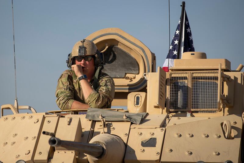 A U.S. soldier observes form the top of a fighting vehicle at a US military base at undisclosed location in Northeastern Syria, Monday, Nov. 11, 2019. A senior U.S. coalition commander said Friday, Nov. 15,  the partnership with Syrian Kurdish forces remains strong and focused on fighting the Islamic State group, despite an expanding Turkish incursion on areas of Kurdish control. (AP Photo/Darko Bandic)