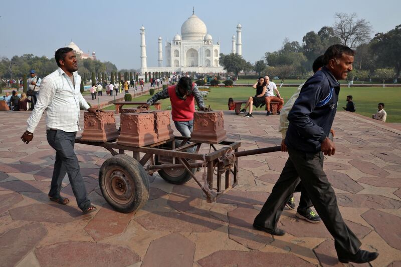Workers move carved stones on a handcart inside the historic Taj Mahal premises, where U.S. President Donald Trump and first lady Melania Trump are scheduled to visit, in Agra, India. REUTERS