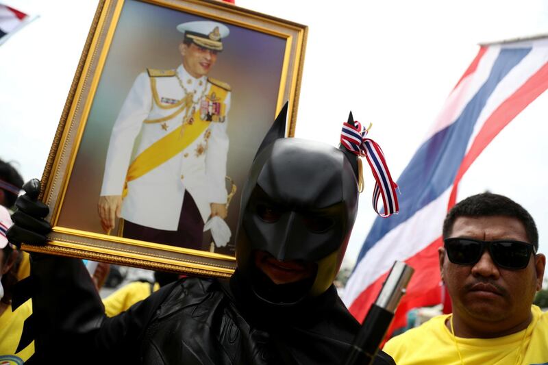 A royalist dressed-up as Batman holds a picture of Thailand's King Maha Vajiralongkorn, near the Royal Plaza in Bangkok. Reuters