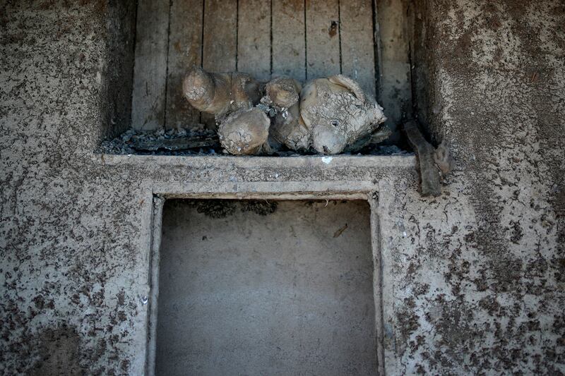 A mud-encrusted teddy bear sits in a formerly sunken boat. AP