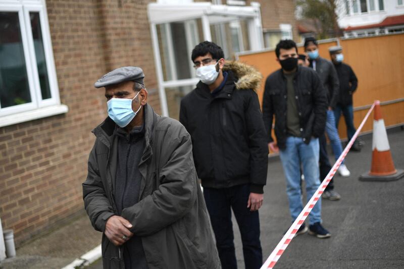 Members of the public form a queue at a coronavirus vaccination centre at the Fazl Mosque in southwest London. AFP