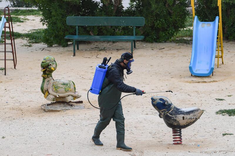 A health worker disinfects the Enahli amusement park at Ariana near Tunis, which has been closed to the public. AFP