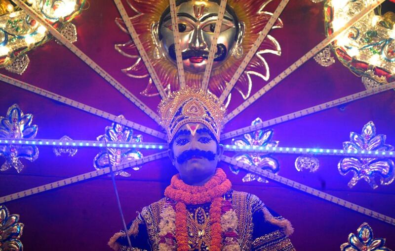 An artist dressed as Son of Hindu demon king Ravana, Meghnath, sits on a chariot as he takes part in a ‘Ravan ki Barat,’ a religious procession held to mark the forthcoming Dussehra festival in Allahabad.  Sanjay Kanojia / AFP