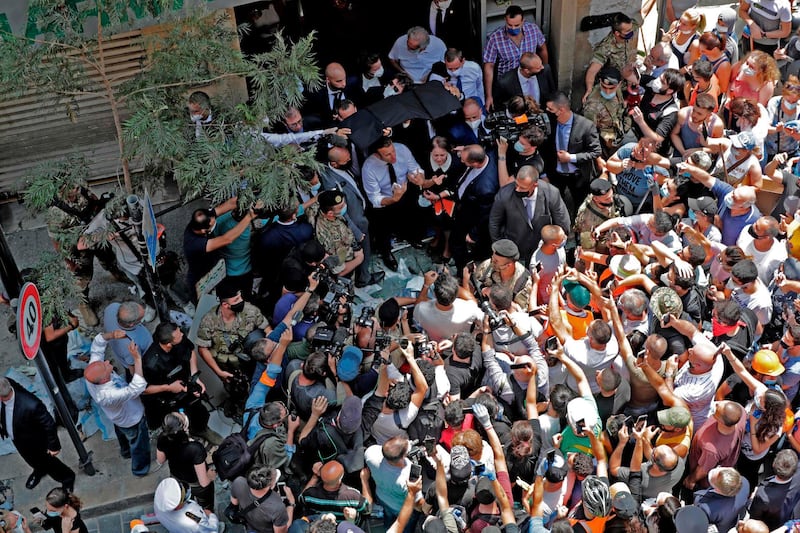 French President Emmanuel Macron speaks to the crowd during a visit to the Gemmayzeh neighbourhood, which has suffered extensive damage due to a massive explosion in the Lebanese capital, on August 6, 2020. French President Emmanuel Macron visited shell-shocked Beirut, pledging support and urging change after a massive explosion devastated the Lebanese capital in a disaster that has sparked grief and fury. / AFP / ANWAR AMRO
