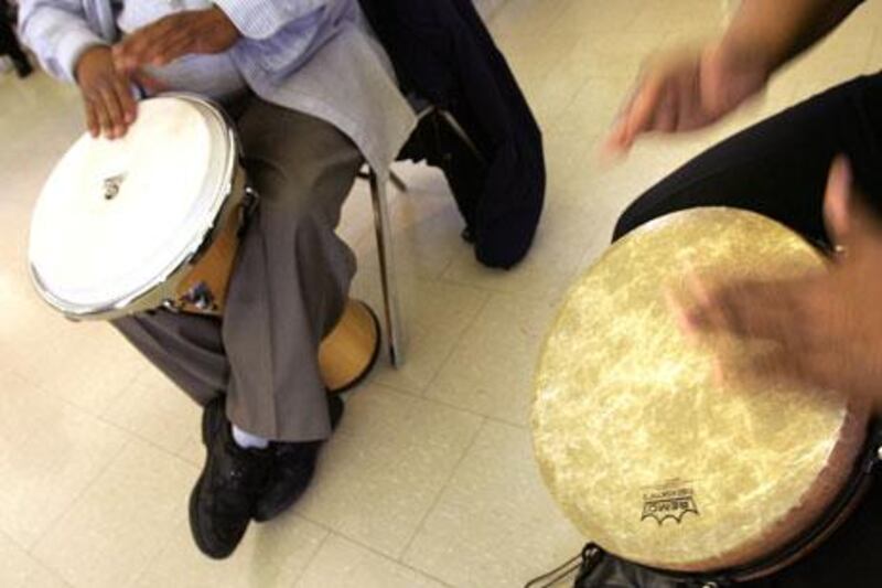 Volunteers bang out some rhythms during Drum Circle, a music-therapy class held for employees at a hospital in the US.