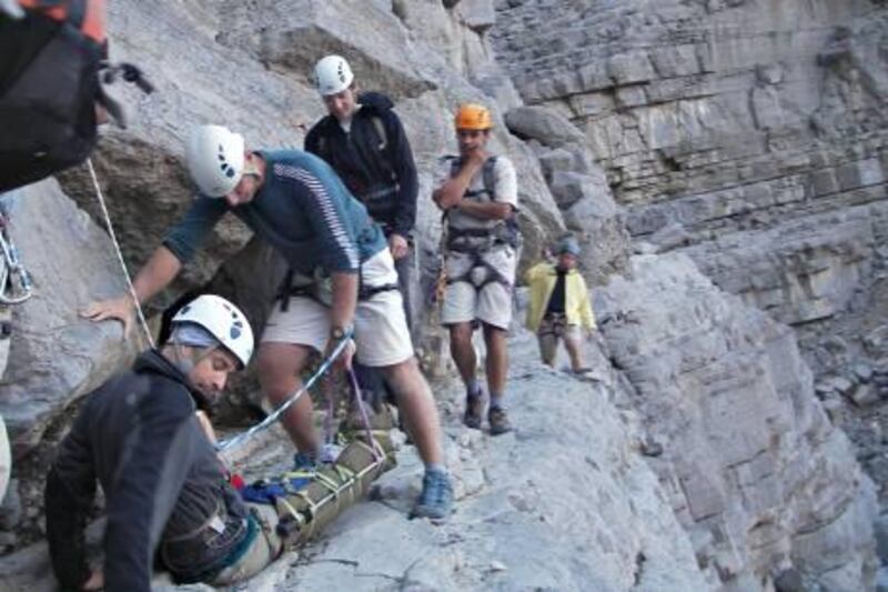 Members of the volunteer rescue team assisting Cameron Brooks, 43, after his 10 metre tumble in Wadi Ghalilah on Saturday. Photo courtesy Dennis Arkwright

