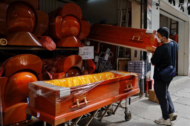 Workers move coffins as mortuaries run short of coffins in Shenzhen. Photo: Reuters
