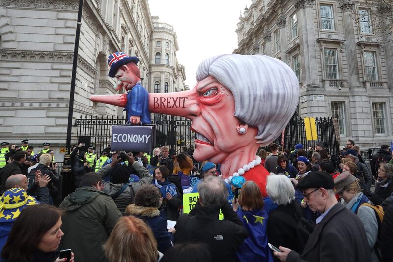 A puppet head of Britain's Prime Minister Theresa May spearing a representation of the British Economy is positioned outside Downing Street. AFP