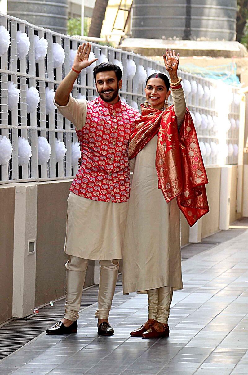 Indian Bollywood actors and recently-wedded couple Ranveer Singh (L) and Deepika Padukone pose after arriving at their residence in Mumbai on November 18, 2018 after being married in Lake Como. Photo / AFP