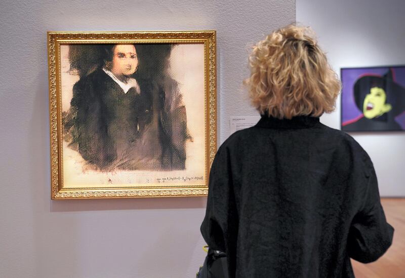 A woman looks at a work of art created by an algorithm by French collective named OBVIOUS which produces art using artificial intelligence, titled "Portrait of Edmond de Belamy" (estimate: $7,000-10,000) at Christie���s in New York on October 22, 2018. - The work of art will be included in the Prints & Multiples auction in New York October 23-25, 2018. (Photo by TIMOTHY A. CLARY / AFP) / RESTRICTED TO EDITORIAL USE - MANDATORY MENTION OF THE ARTIST UPON PUBLICATION - TO ILLUSTRATE THE EVENT AS SPECIFIED IN THE CAPTION