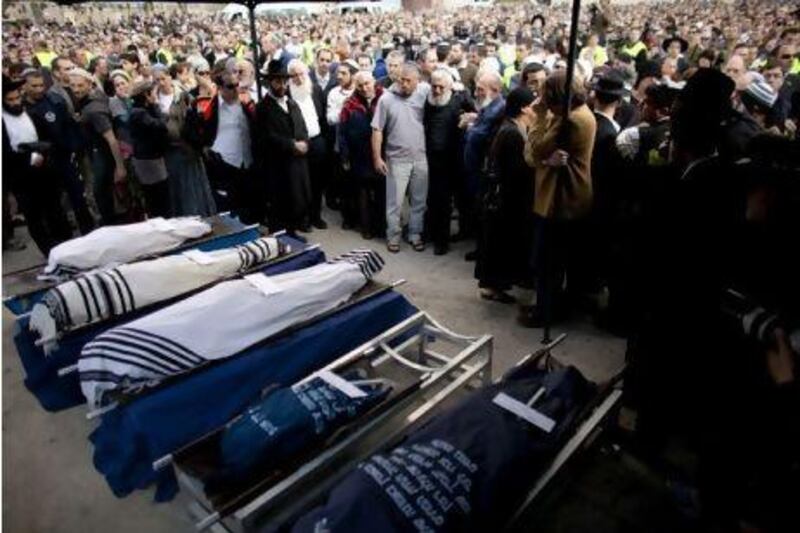 Mourners stand around the bodies of Ehud Fogel, 36, his wife Ruti, 35, and their children, 11-year-old Yoav, 4-year-old Elad, and 3-month-old Hadas, during their funeral in Jerusalem.