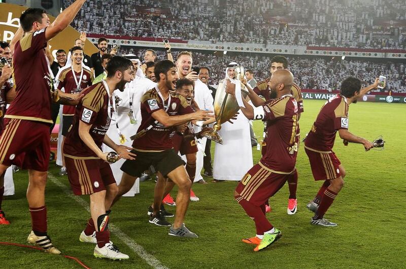 Ismail Matar holds the President's Cup trophy during Al Wahda's on-pitch celebrations. Pawan Singh / The National