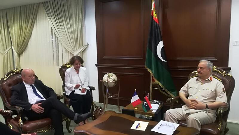France's Foreign Minister Jean-Yves Le Drian (L) meets with Libya's Field Marshal Khalifa Haftar (R), whose self-styled Libyan National Army dominates the country's east, at the Rajma military base 25 kilometres east of Benghazi on July 23, 2018. The visit by France's top diplomat follows May talks in Paris which for the first time brought together rival Libyan leaders including the UN-backed Prime Minister Fayez al-Sarraj and Haftar. / AFP / Valérie LEROUX

