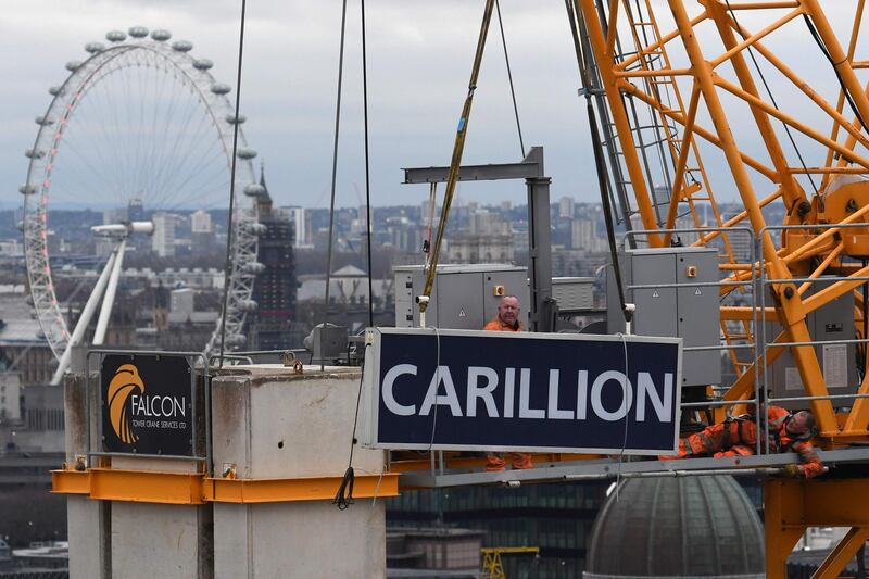 Workers take down a sign showing the name of liquidated British construction and outsourcing group Carillion from a construction crane on a building site in the City of London on January 23, 2017.
British construction and outsourcing firm Carillion, which has a variety of private and public service contracts in Britain and employs 43,000 staff worldwide, announced its immediate liquidation on January 15 after the heavily-indebted company failed to secure a last-minute financial rescue by the government and banks. / AFP PHOTO / Daniel SORABJI