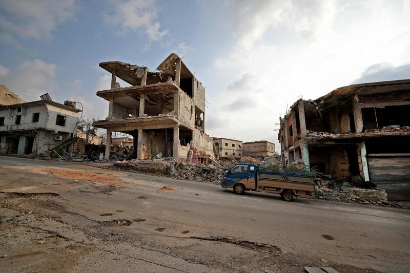 A truck rides past destroyed buildings in the town of Ihsim in the southern countryside of Idlib.  AFP