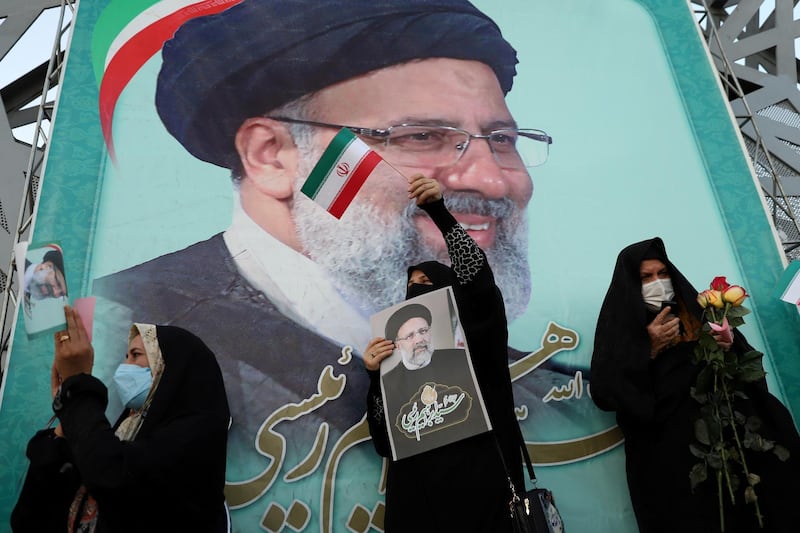 FILE PHOTO: A supporter of Ebrahim Raisi displays his portrait during a celebratory rally for his presidential election victory in Tehran, Iran June 19, 2021. Majid Asgaripour/WANA (West Asia News Agency) via REUTERS ATTENTION EDITORS - THIS IMAGE HAS BEEN SUPPLIED BY A THIRD PARTY./File Photo