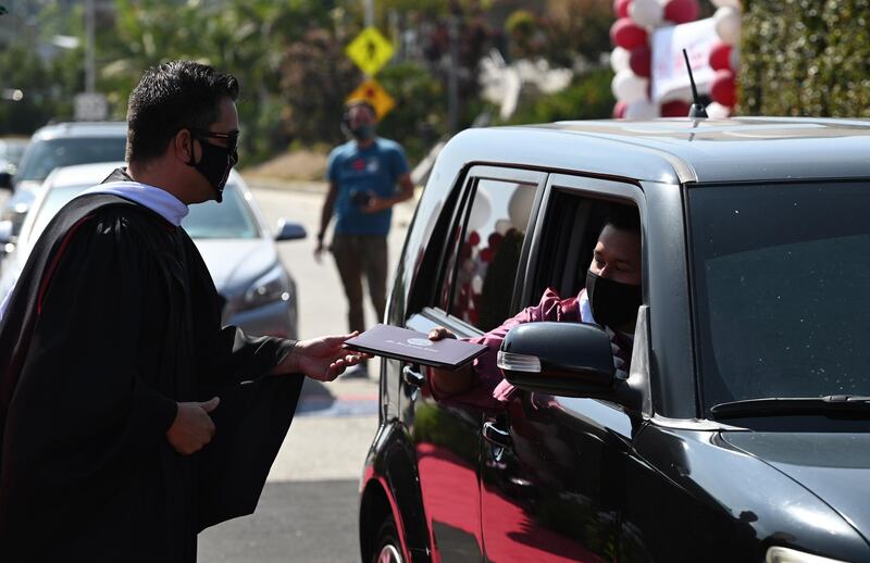 Members of the faculty of Mount San Antonio College present diplomas to graduating students at the school's first drive-thru commencement ceremony, in Walnut, California, USA. AFP
