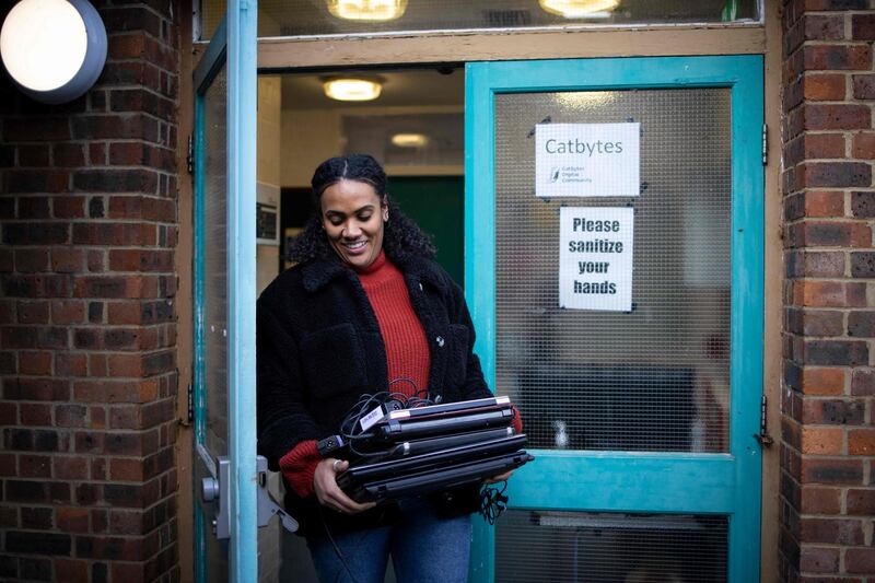 A member of staff from a school picks up repaired computers from Catbytes. AFP