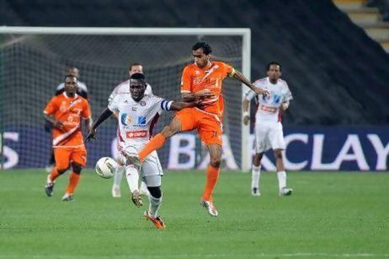 Al Jazira's Ibrahim Diaky, left, tries to shield the ball against Ajman's Jasem Al Mohammed.