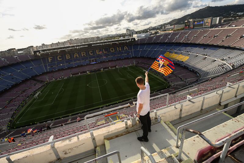 A fan waves a Barcelona flag as he arrives at the Camp Nou stadium prior to the Champions League match between Barcelona and Dinamo Kiev on October 20, 2021. Getty Images