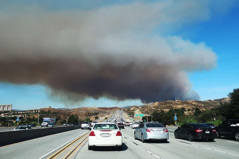 People drive on a freeway as the Tick Fire burns in nearby Canyon Country. AFP