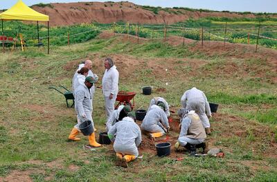 FILE - In this March 15, 2019 file photo, workers start the exhumation process of a mass grave in Iraq's northwestern region of Sinjar. U.N. investigators have collected millions of call data records implicating Islamic State militants in atrocities committed in northern Iraq, but delays in passing a law to govern war crimes probes is hindering the pursuit of justice, according to the head of the investigation. Hundreds of suspects have been identified in connection to atrocities committed against the Yazidi minority in 2014, when IS swept across northern Iraq. Karim Khan, leading the investigation, said the use of 3D technology is helping with the analysis of mass grave sites. (AP Photo/Farid Abdulwahed, File)