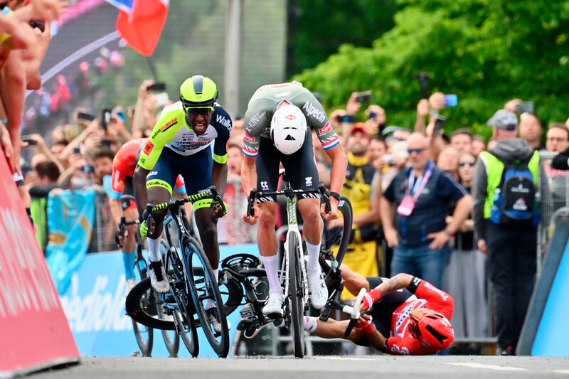 Mathieu van der Poel crosses the finish line ahead of Biniam Girmay as Caleb Ewan falls. AP