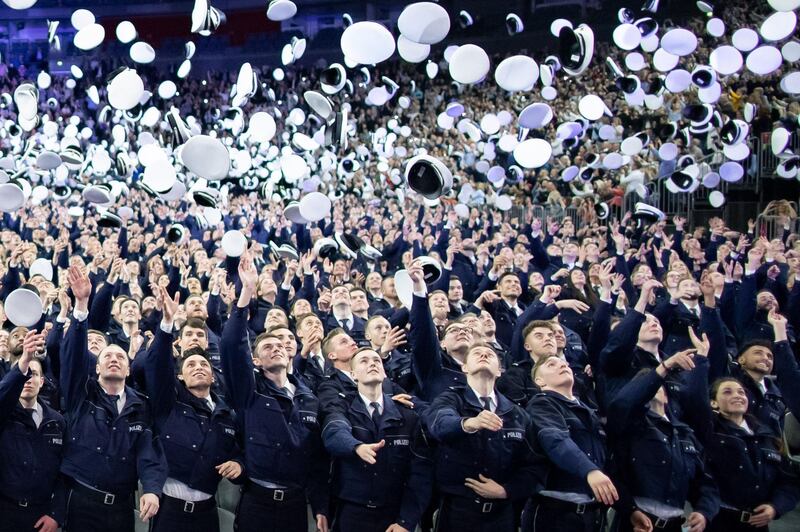 Police inspector graduates throw their hats up during a swearing-in ceremony in Cologne, western Germany. AFP