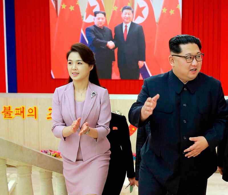 FILE - In this April 14, 2018, file photo provided  by the North Korean government, Ri Sol Ju claps while walking with her husband, North Korean leader Kim Jong Un, right, in Pyongyang, North Korea. Six years into his reign, Kim appears to be putting the spotlight on the women in his life. Over the past few months, Kim has increasingly shared the stage with his younger sister Kim Yo Jong, who became an instant celebrity as his envoy to the Pyeongchang Winter Olympics, and his wife Ri Sol Ju, a former singer in her late 20s. Independent journalists were not given access to cover the event depicted in this image distributed by the North Korean government. The content of this image is as provided and cannot be independently verified. (Korean Central News Agency/Korea News Service via AP)