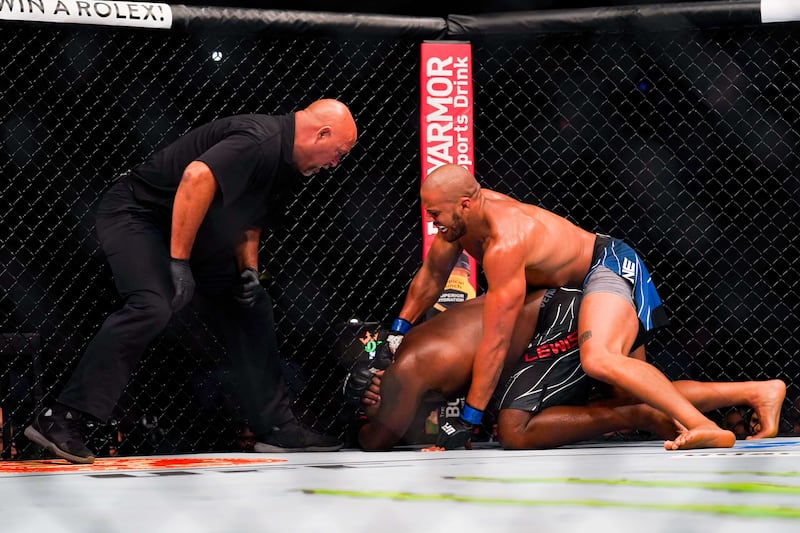 Ciryl Gane punches Derrick Lewis on the mat. AFP