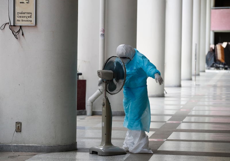 A health worker wearing a full protective suit cools down with an electric fan during a free Covid-19 test for at-risk people amid the coronavirus pandemic in Bangkok, Thailand. EPA