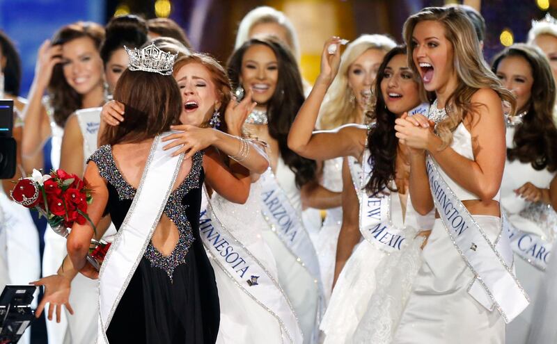 FILE - In this Sunday, Sept. 10, 2017, file photo, Miss North Dakota Cara Mund is congratulated by contestants after being named Miss America during Miss America 2018 pageant in Atlantic City, N.J. With a revolt underway by state pageant officials _ and without swimsuits _ the Miss America competition begins Wednesday night amid the most turmoil the iconic event has seen in decades. (AP Photo/Noah K. Murray, File)