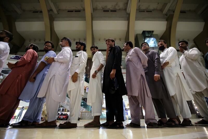 Shopkeepers queue to receive a dose of the Pak Vac vaccine at a shopping mall in Peshawar, Pakistan. EPA