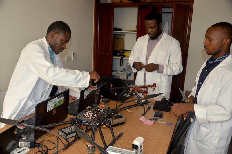 Three young Cameroonian engineers from the Will and Brothers start up work on a drone at a workshop in Douala on February 16, 2018.
Created by William Elong, 25, the start up aims at selling worldwide the first drone entirely developed and built in Cameroon.  / AFP PHOTO / Reinnier KAZE