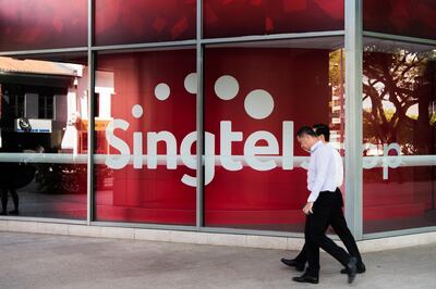 A pedestrian walks past a Singapore Telecommunications Ltd. (SingTel) store in Singapore, on Monday, Feb. 29, 2016. Singapore's Infocomm Development Authority plans to auction additional mobile spectrum this year as it seeks to lure a new entrant to compete with the city's three existing providers. Photographer: Nicky Loh/Bloomberg