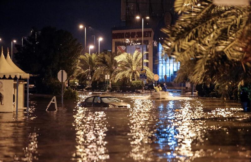 People are having fun with a boat on the flooded main road of the Daeya area of Kuwait city late on November 14, 2018, following heavy rain in the Gulf emirate, four days after flash floods hit the Gulf emirate, killing a man and causing damage to roads, bridges and homes.  / AFP / Yasser Al-Zayyat

